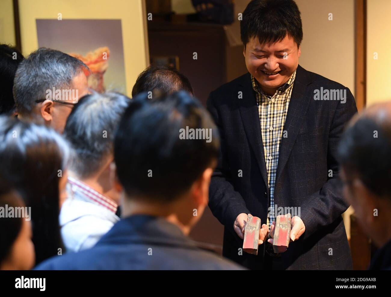 (201208) -- HANGZHOU, Dec. 8, 2020 (Xinhua) -- Jiang Sihai, vice president of the Changhua stone industry association, presents Jixue stones to visitors at a seal culture experience museum in Changhua Town of Lin'an District, Hangzhou City of east China's Zhejiang Province, Nov. 6, 2020. The Jixue stone, featuring chicken-blood bright red traces, a local specialty in Changhua Town of Hangzhou City, is a highly sought-after material for making seals and carving handicrafts. Inspired by its colors, artisan have been bringing ingeniously-designed and broadly-themed creations throughout its long h Stock Photo