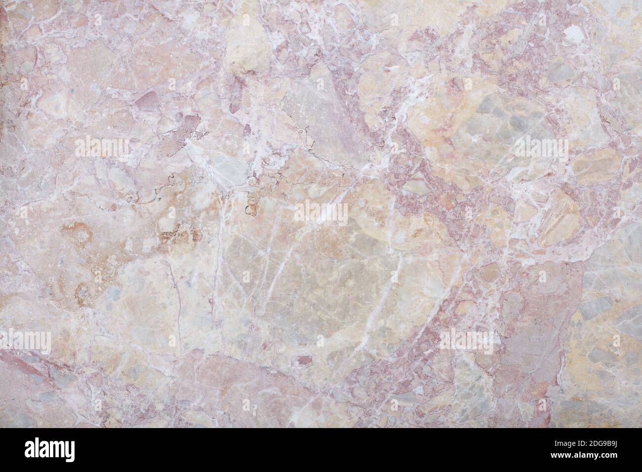Variegated rough stone with grey, pink, and beige colors texture background Stock Photo