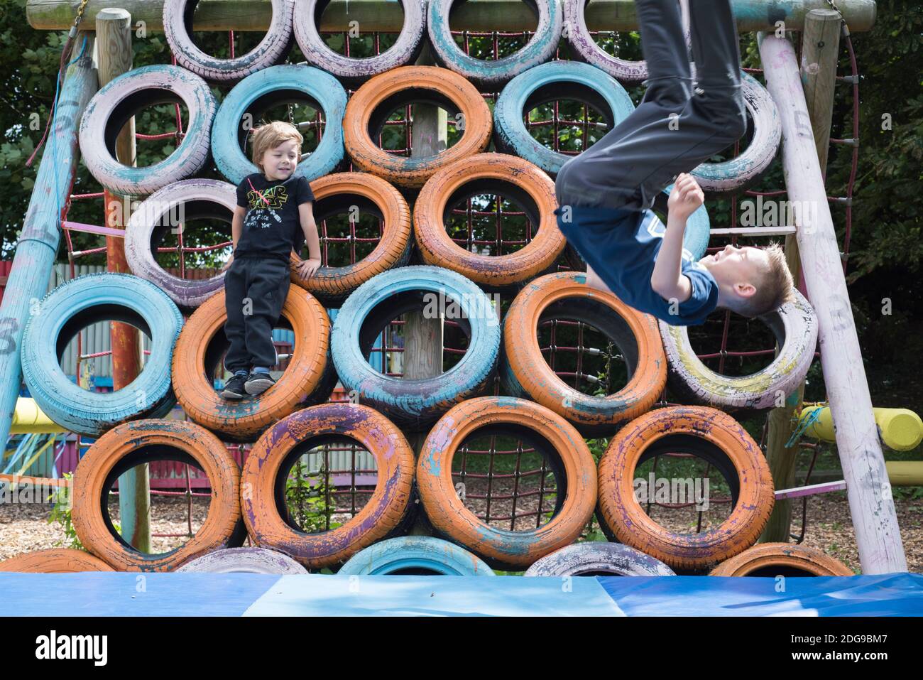 Knottingley, UK – 04 Aug 2017 – Children love leaping off the tyre climbing frame at The Addy, The Old Quarry Adventure Playground at Warwick Estate Stock Photo