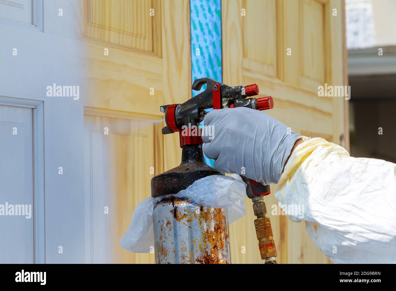 Hand with spray gun painting wooden door Stock Photo Alamy