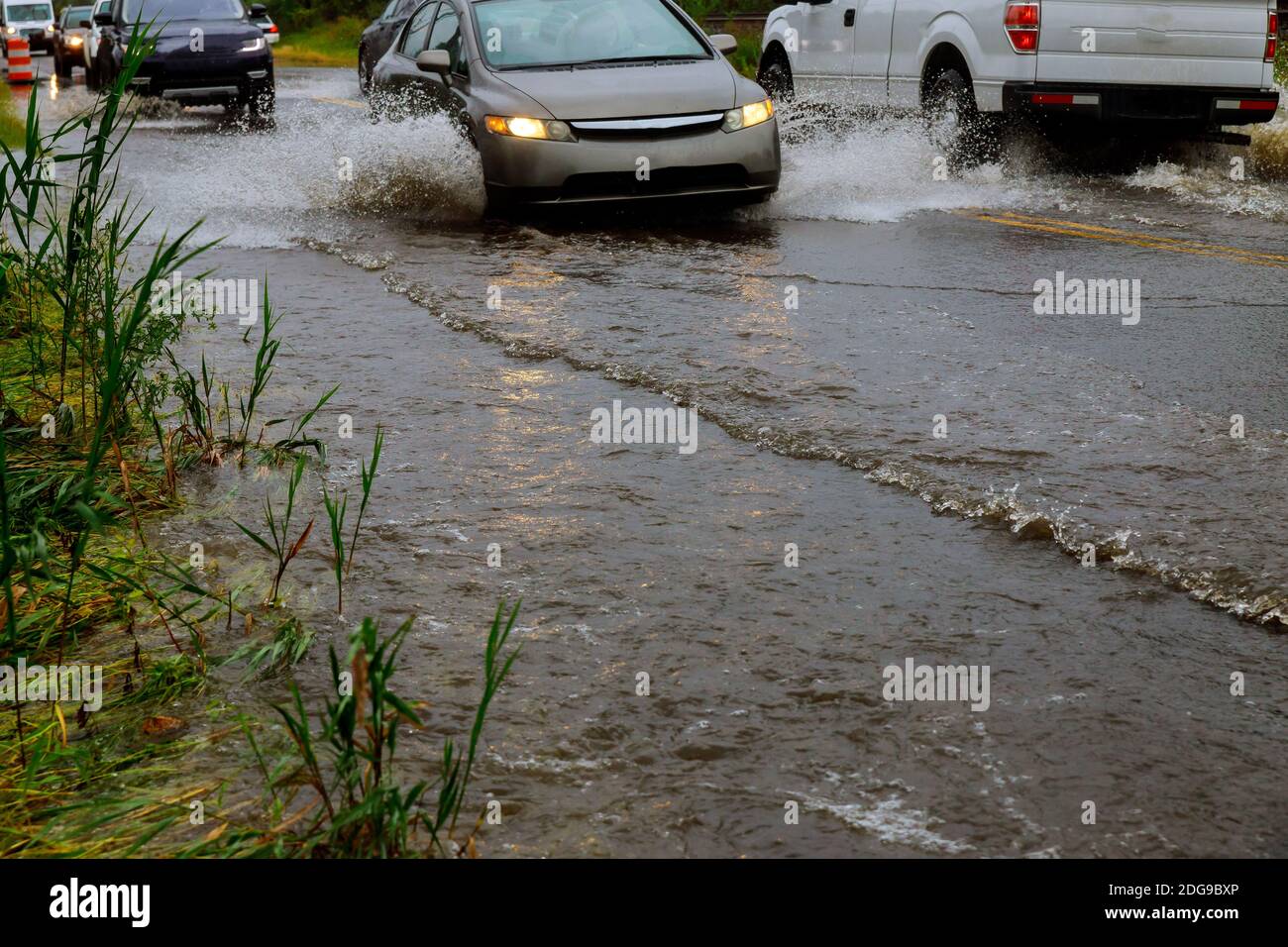 Car driving through flood water on the road during monsoon season Stock Photo
