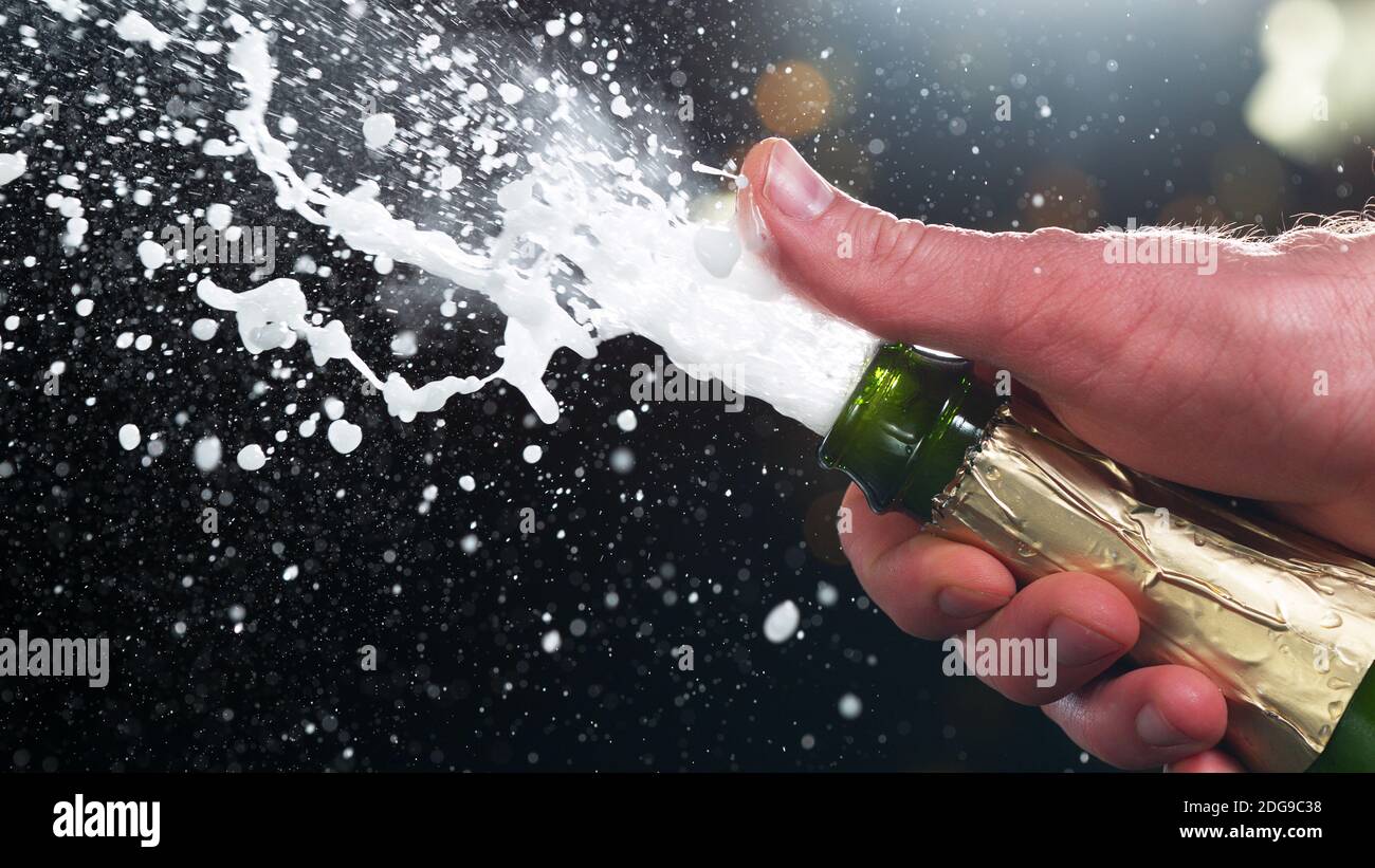 Champagne popping, detail of bottle with wine explosion. Holidays and