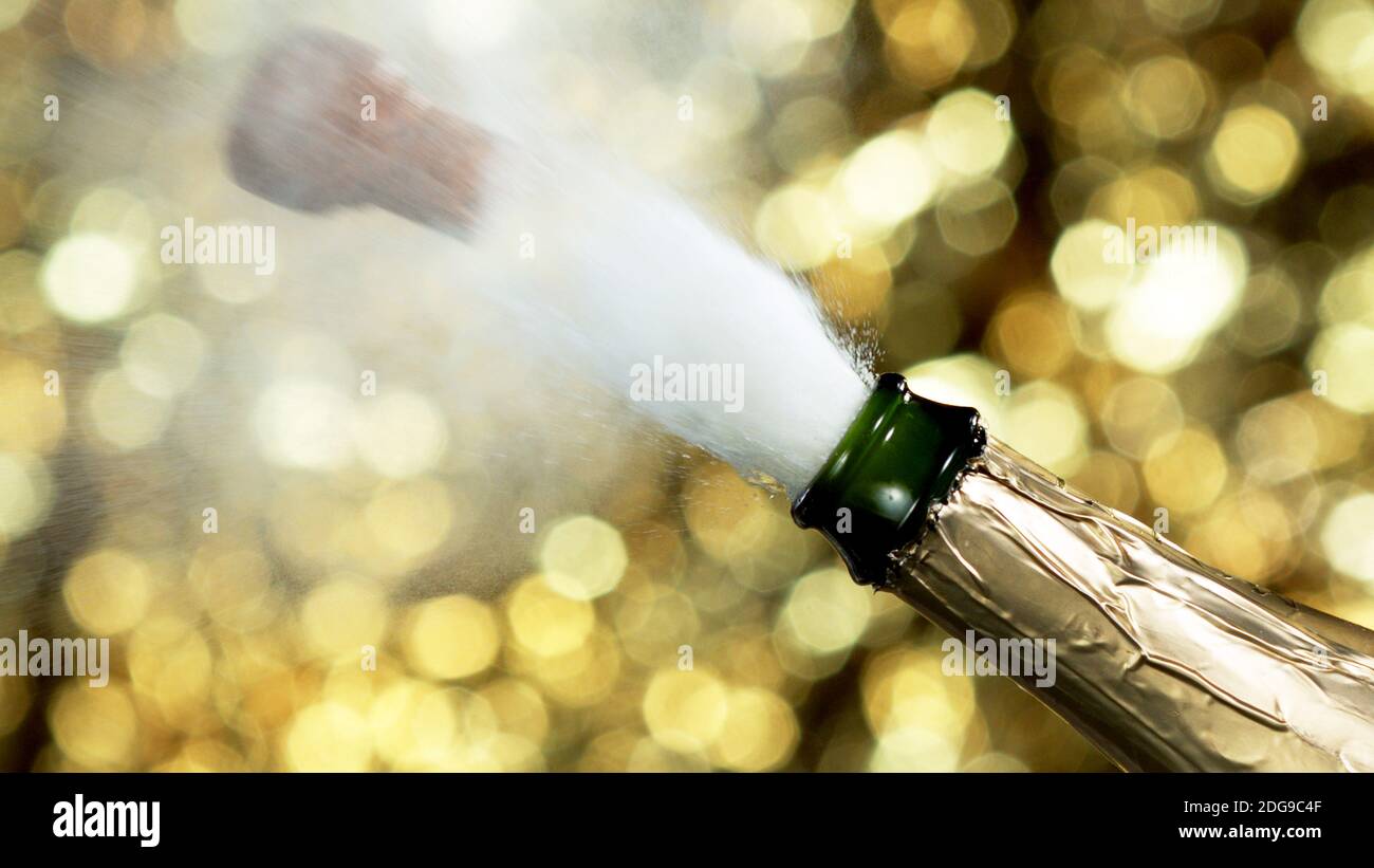 Detail of champagne wine splashing from bottle with neon lights. Celebration and holiday theme. Stock Photo