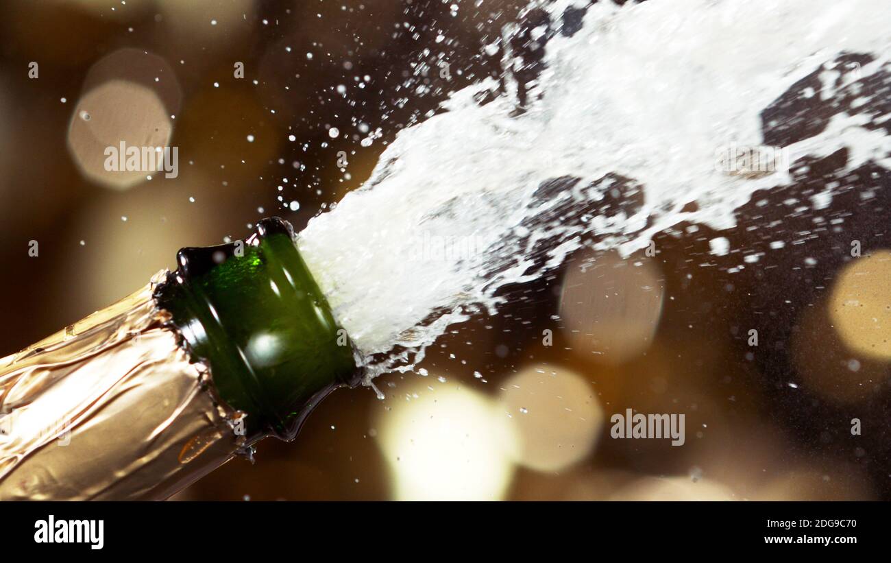 Detail of champagne wine splashing from bottle. Celebration and holiday theme. Stock Photo
