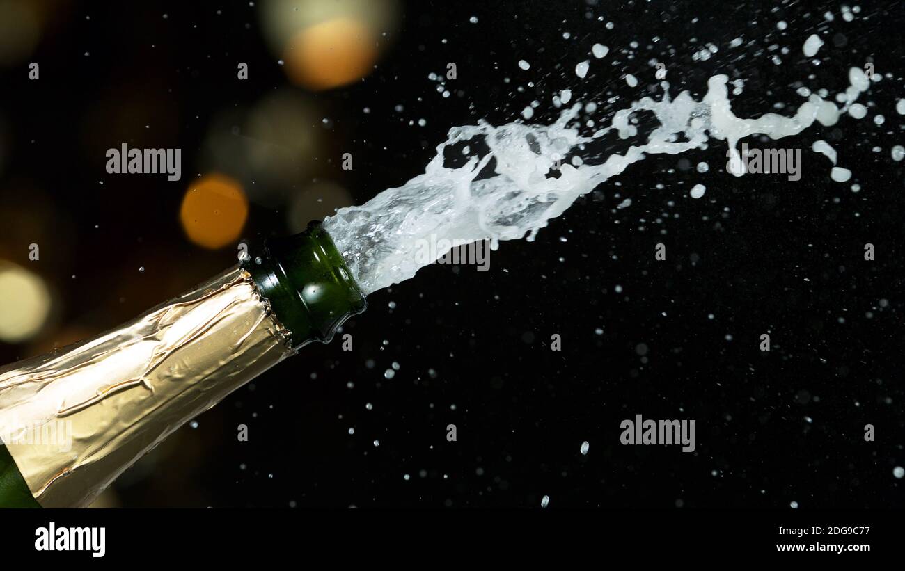 Detail of champagne wine splashing from bottle. Celebration and holiday theme. Stock Photo