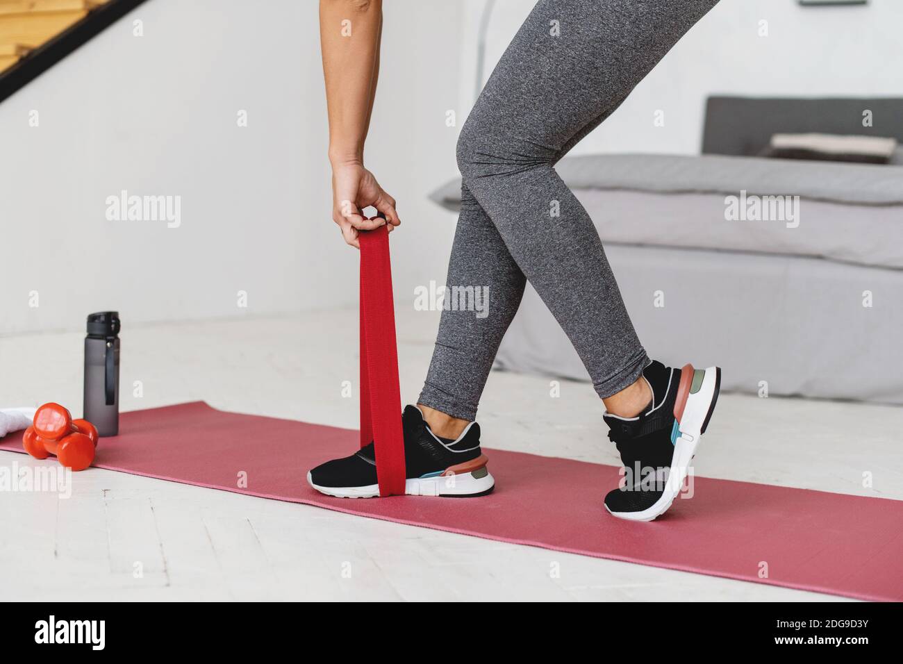 Cropped image of woman doing exercises with resistance bands at home. Stock Photo