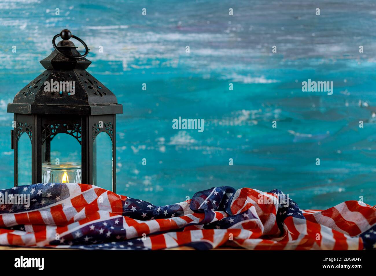 Lighted candle with an American flag, turquoise background Stock Photo