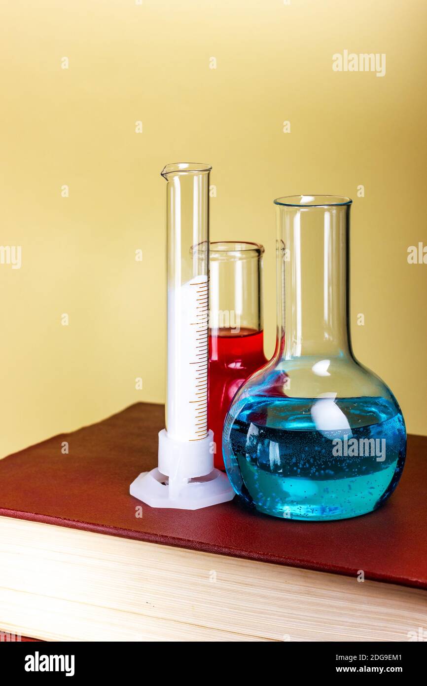 Chemical dishes and test tubes are on a thick book. Laboratory research ...