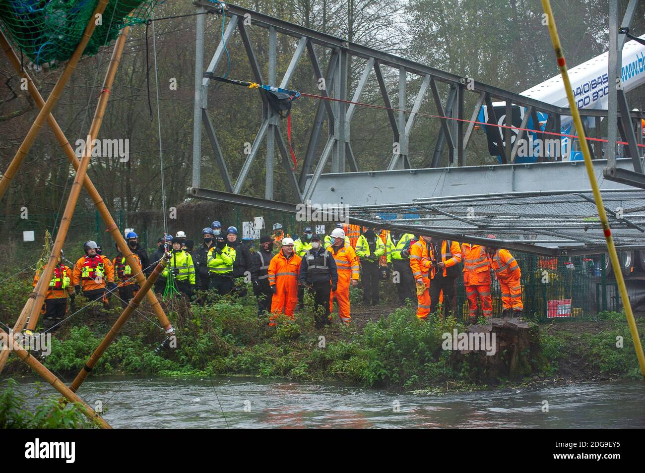 Denham, Buckinghamshire, UK. 8th December, 2020. A huge Police and HS2 operation is underway to try to remove Veteran eco activist Dan Hooper known as Swampy who is currently locked onto a 30 feet tall high  bamboo structure in the River Colne in Denham Country Park. HS2 are building a temporary bridge across the river and Anti HS2 Rebellion activists are are trying to stop the bridge being built and further trees being destroyed by HS2 for the controversial High Speed Rail link. Credit: Maureen McLean/Alamy Live News Stock Photo
