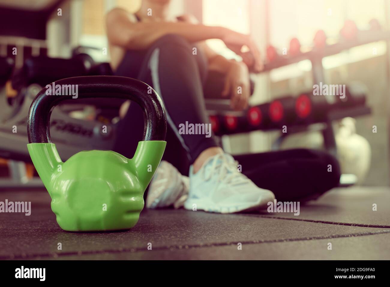 Woman exercise at gym fitness breaking relax after kettlebell workout or sitting tired. Concept fitness ,workout, gym exercise ,lifestyle and healthy. Stock Photo