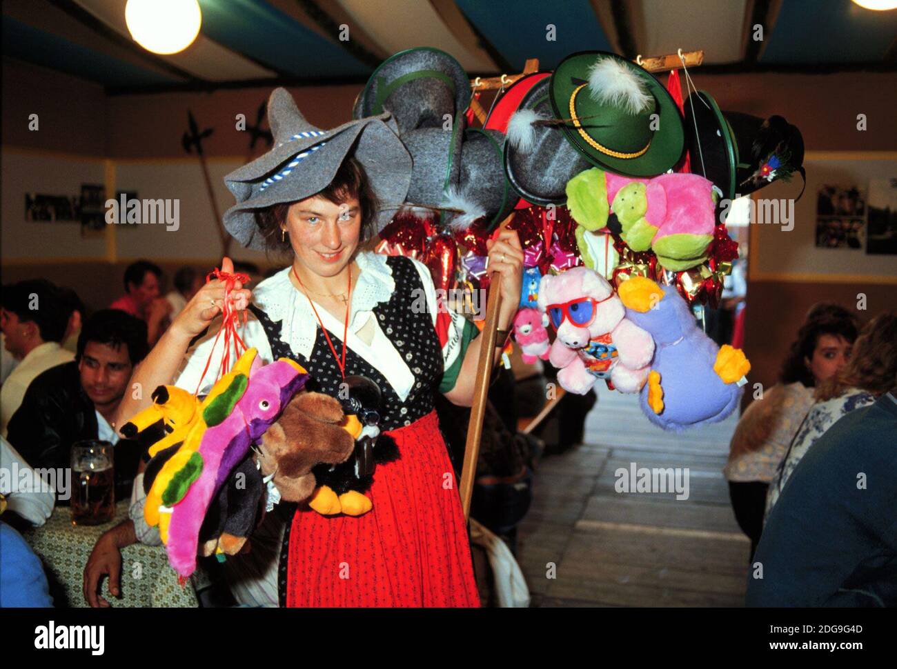 Impressionen vom Münchener Oktoberfest hier eine Frau die Hüte und Stofftiere verkauft, 1998. Impressions of the Munich Oktoberfest here a woman selling hats and stuffed animals, 1998. Stock Photo