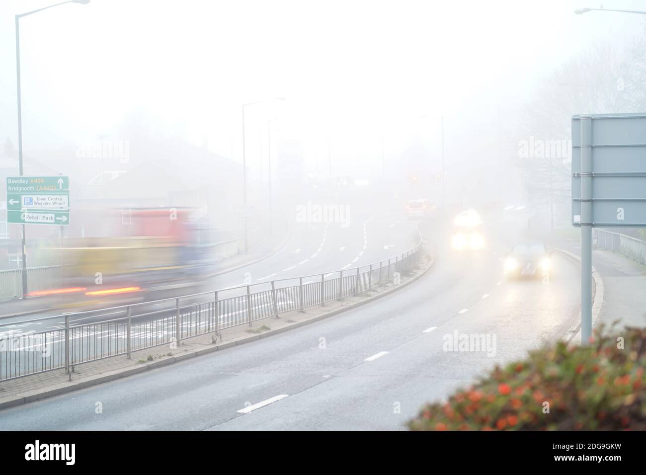 Speeding traffic in murky fog and mist with vehicle motion blur. Stock Photo