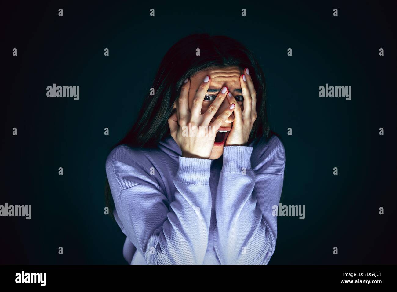 Hiding. Portrait of young crazy scared and shocked caucasian woman ...