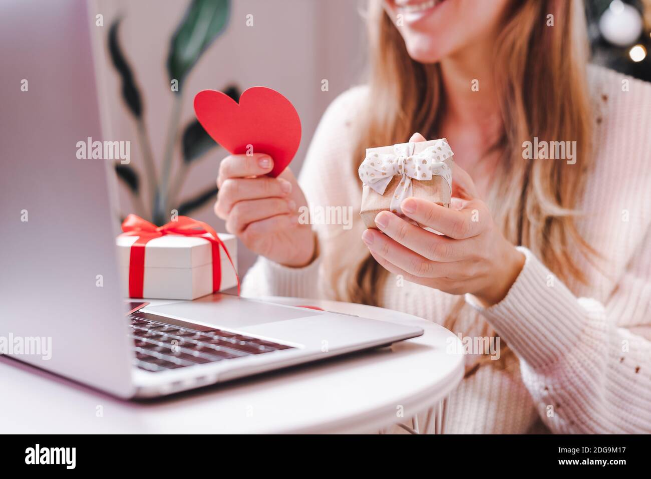 Smiling Woman with Valentine greeting card and gift box having a video call  chat on laptop, online shopping, enjoy holidays at home. Selective focus  Stock Photo - Alamy