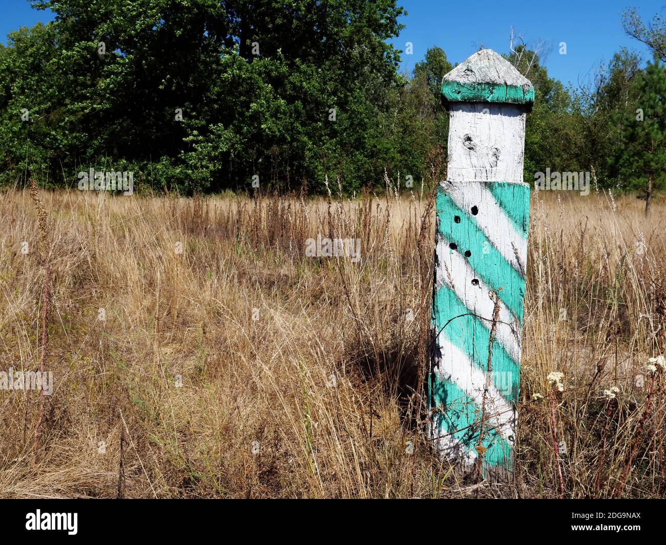 A milestone in the field. Symbol of reaching point, goal. Stock Photo