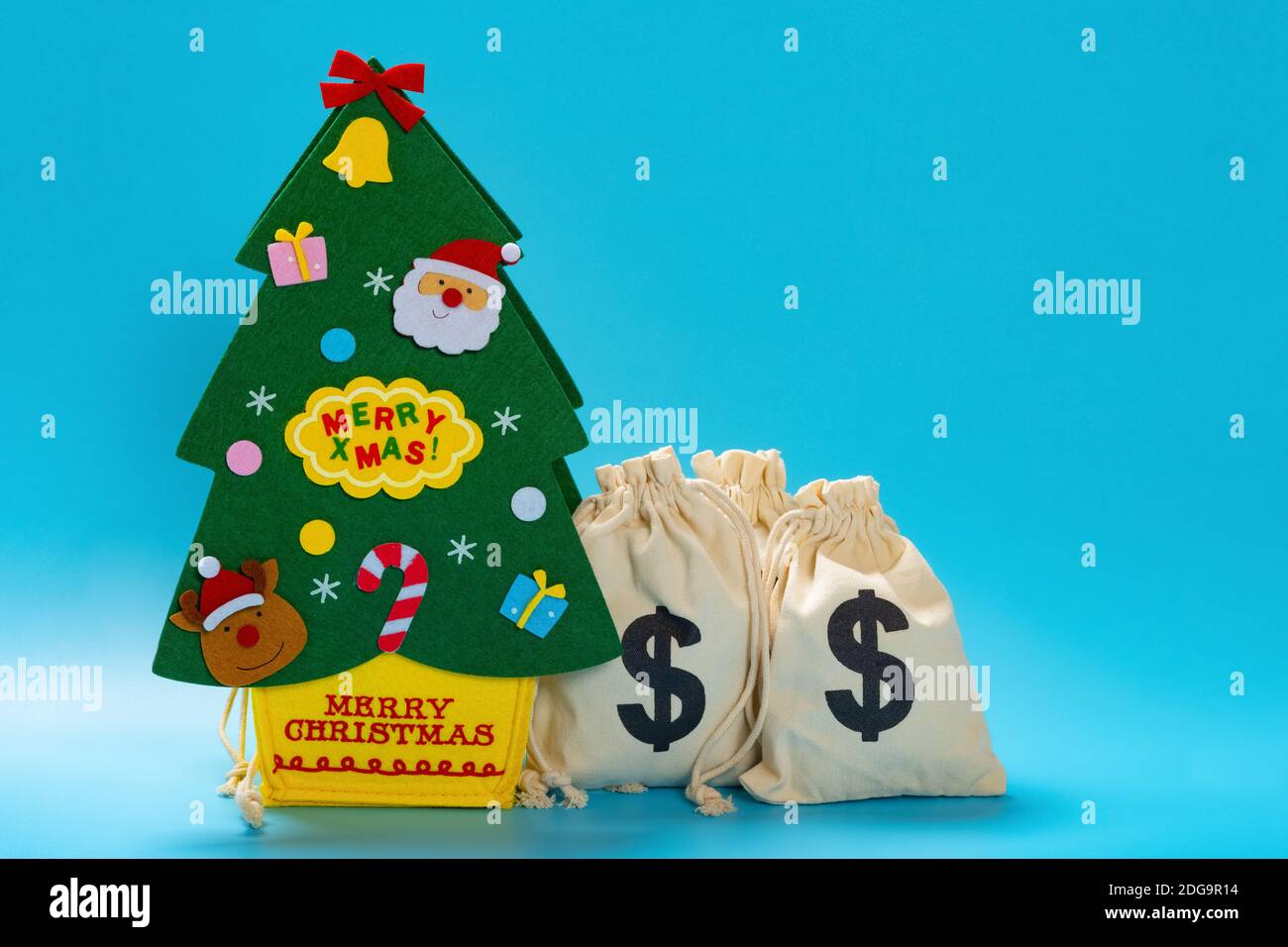 Christmas tree shape package with US money bags on blue background Stock Photo