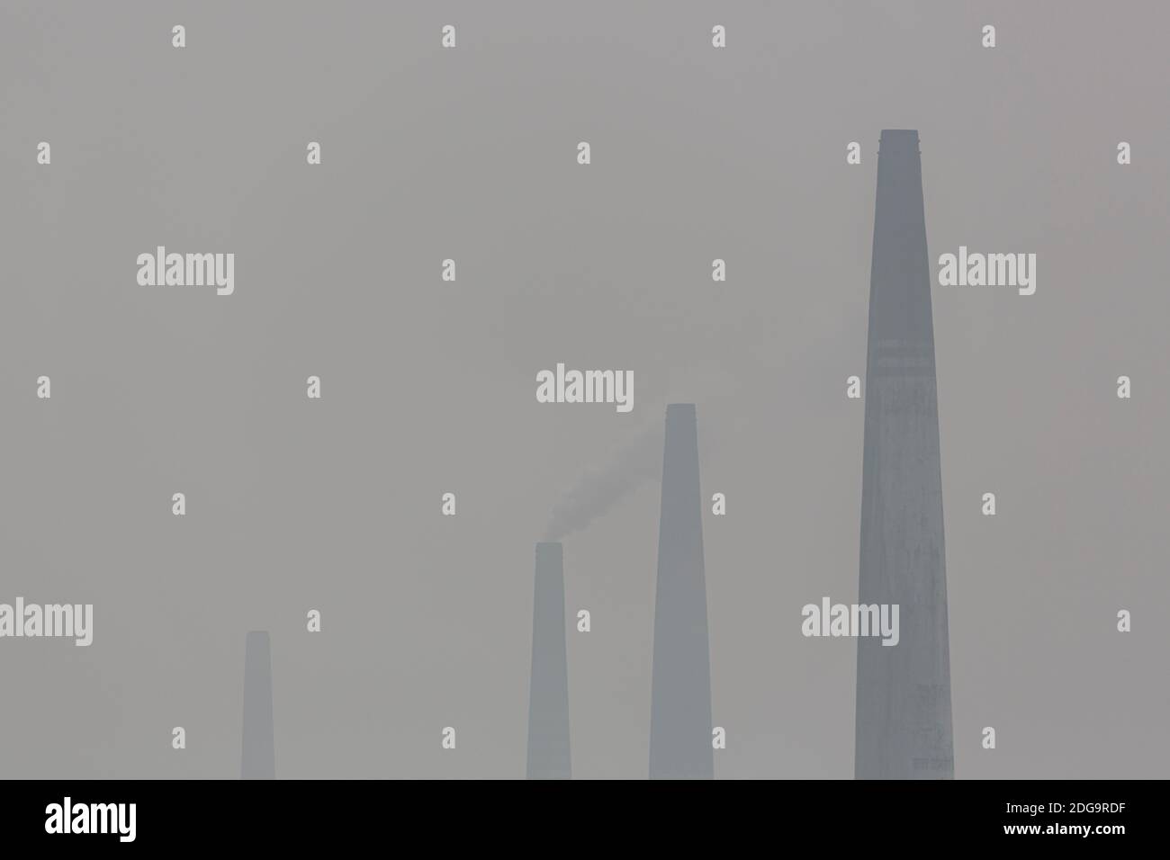 Smoke stacks from fixed chimney brick kilns along the hazy Turag river