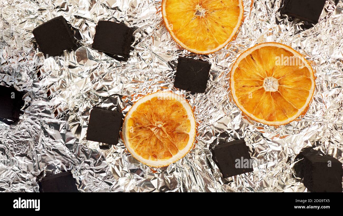 Coals for hookah on foil background with dry oranges Top view Stock Photo Alamy