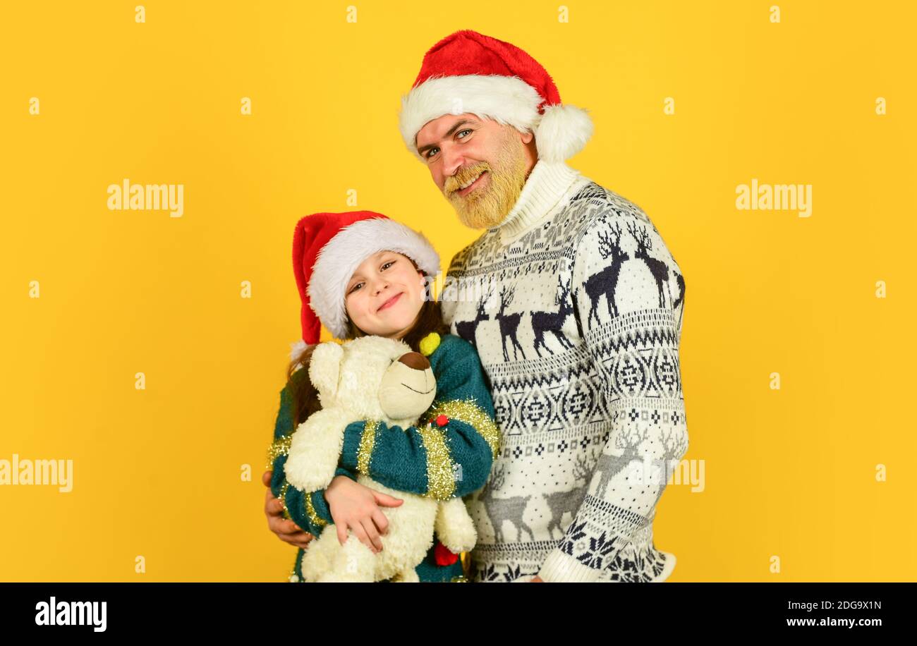 funny knitted sweater. father and daughter celebrate christmas. xmas party  together. . winter family holiday. new year is here. bearded dad and small  girl santa hat with toy Stock Photo - Alamy