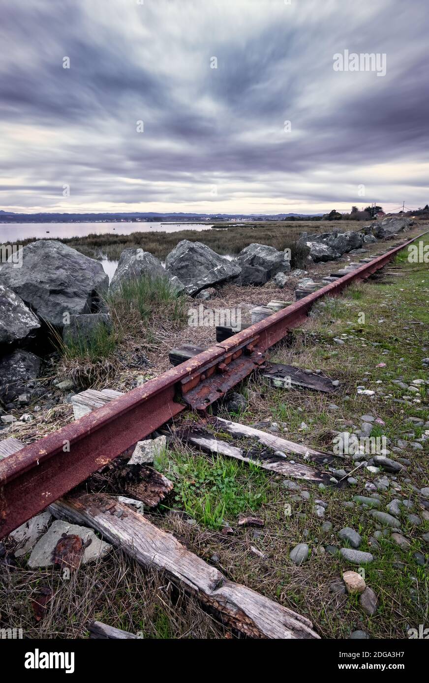 An Abandoned Railroad Track Rusts Under Stormy Skies Stock Photo