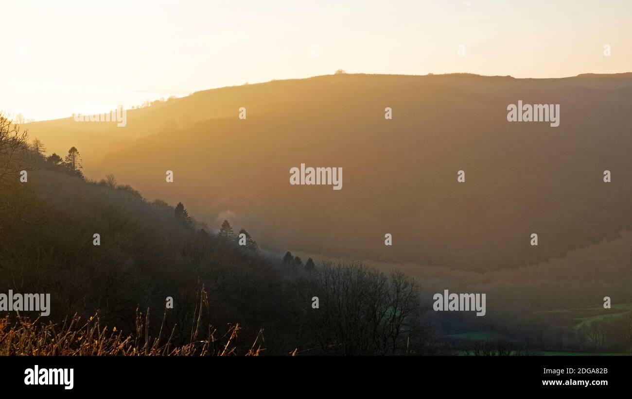 Late afternoon autumn misty silhouette of hills landscape in November golden sunset in Llanwrda Carmarthenshire West Wales UK  KATHY DEWITT Stock Photo