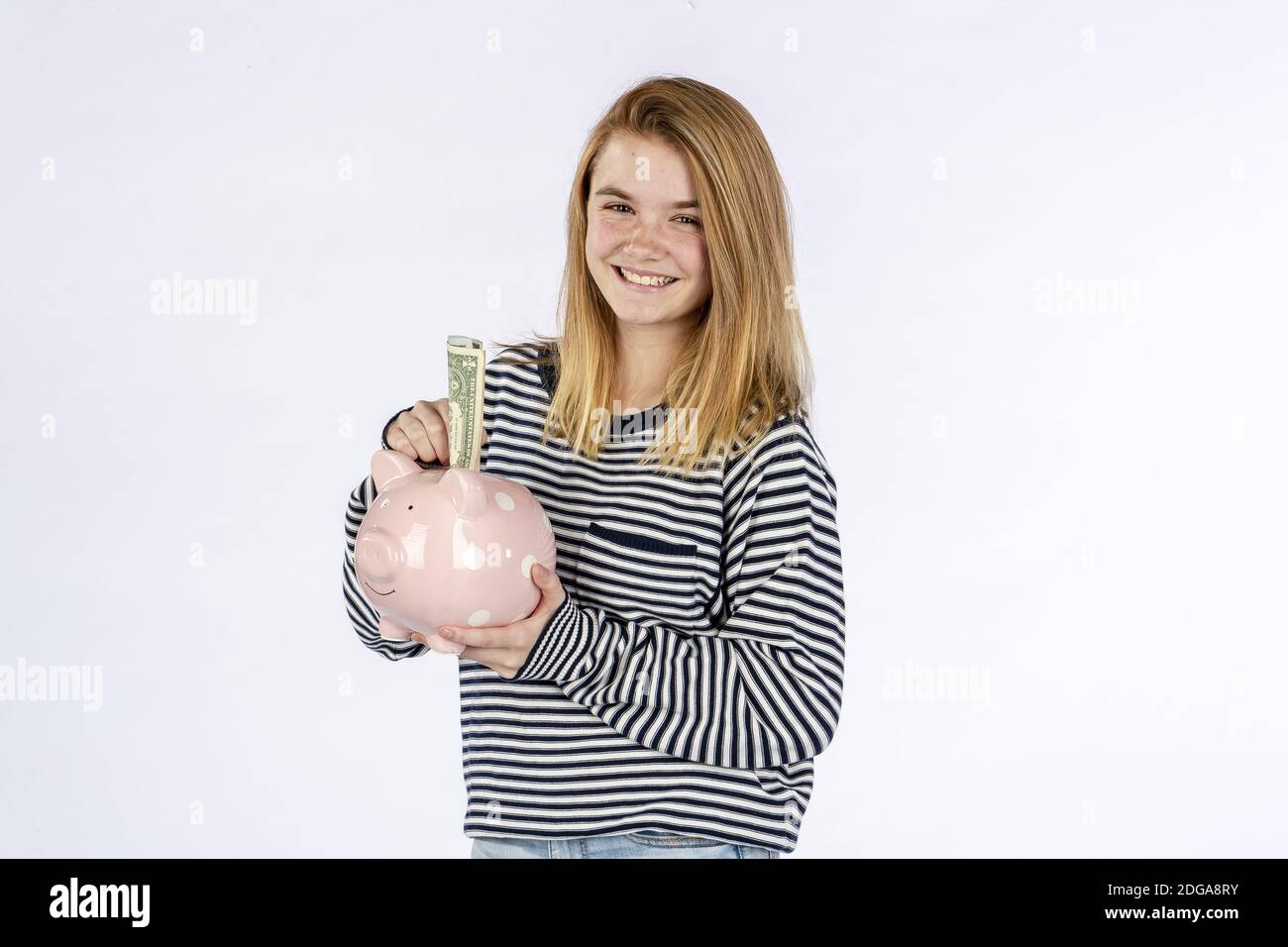 Beautiful Blonde Teenage Model Holding A Piggy Bank Against A White ...