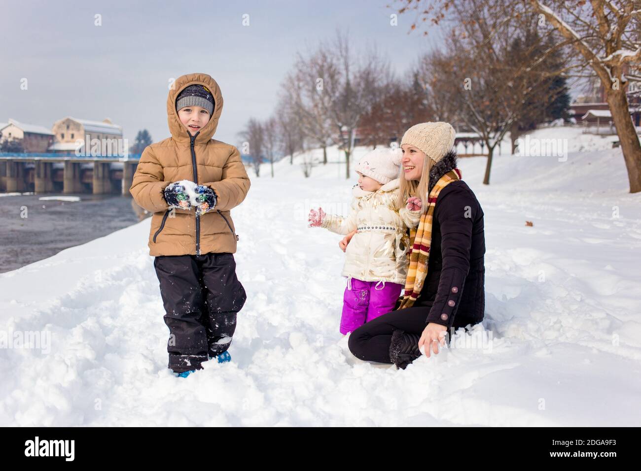 Happy family, mom with son and daughter in winter clothing, winter time, outdoor activity Stock Photo