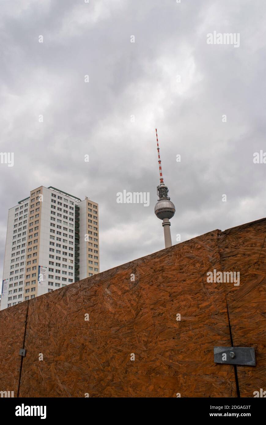 television tower and plattenbau building behind a construction site fence, Berlin, Germany Stock Photo