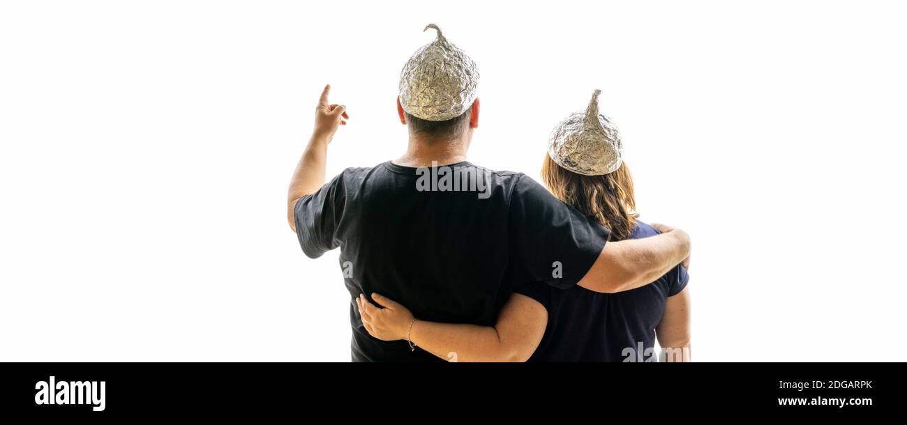A man looks into the future with his wife, both wearing aluminum hats. Stock Photo
