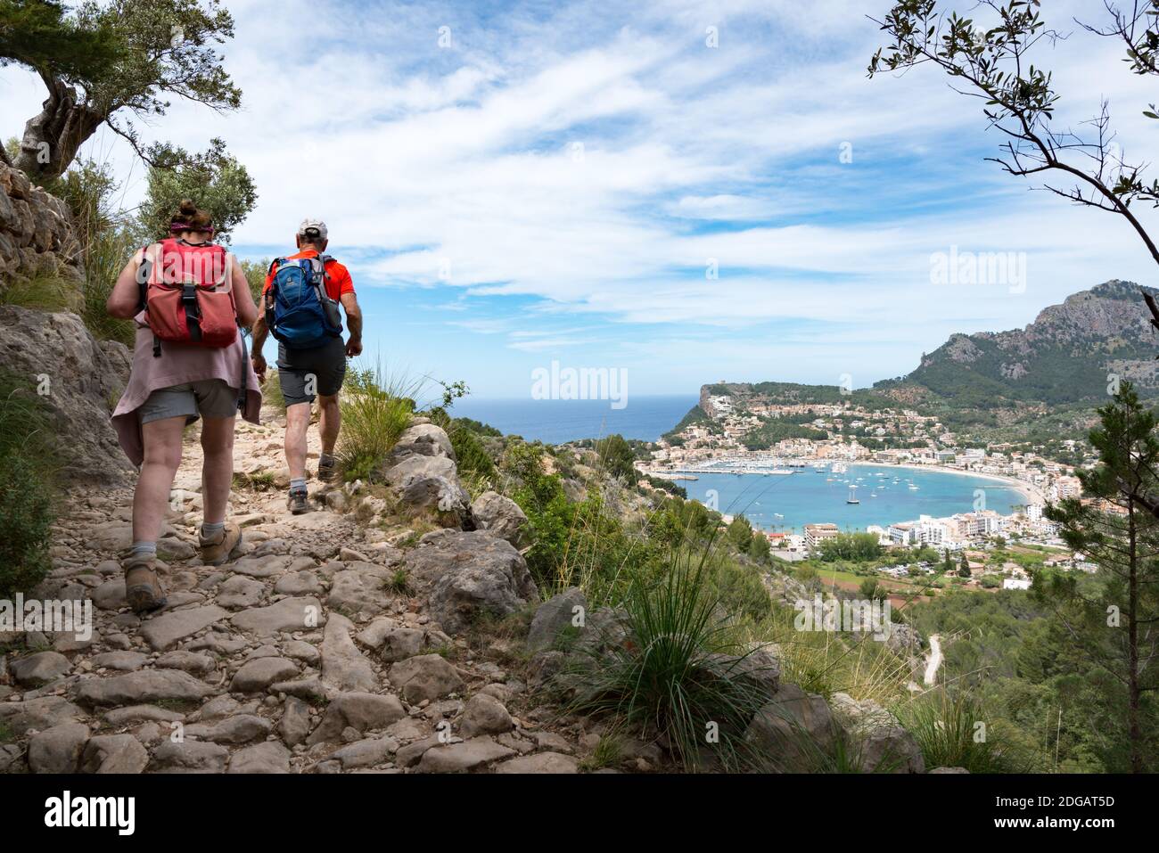 A couple hiking the GR221 walk overlooking the bay of Port de Soller, Mallorca, Spain Stock Photo