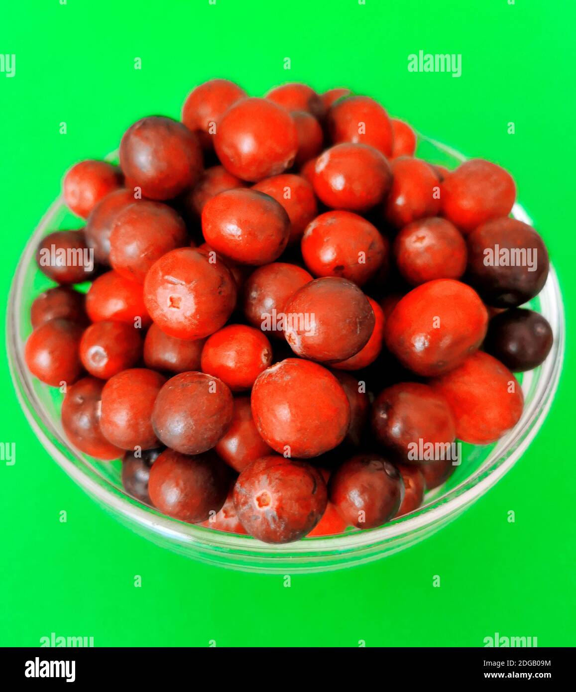 Freshly washed raw cranberries in a glass bowl on green background Stock Photo