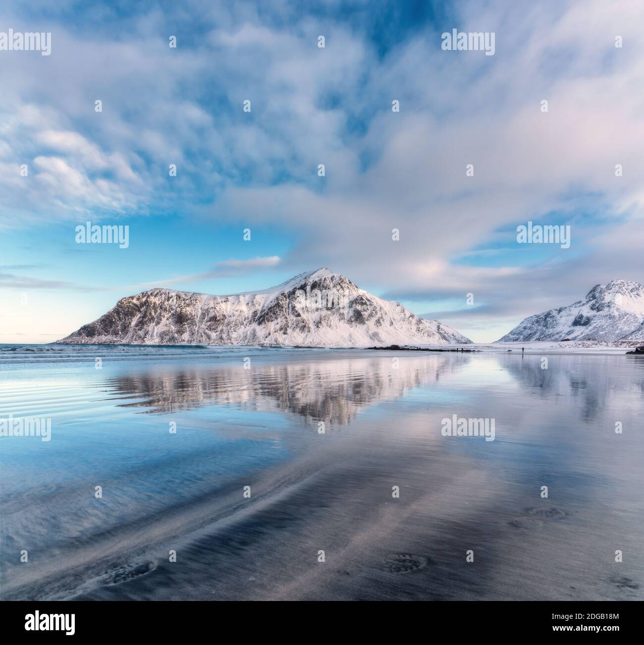 Snowy mountains and blue sky with clouds reflected in water Stock Photo