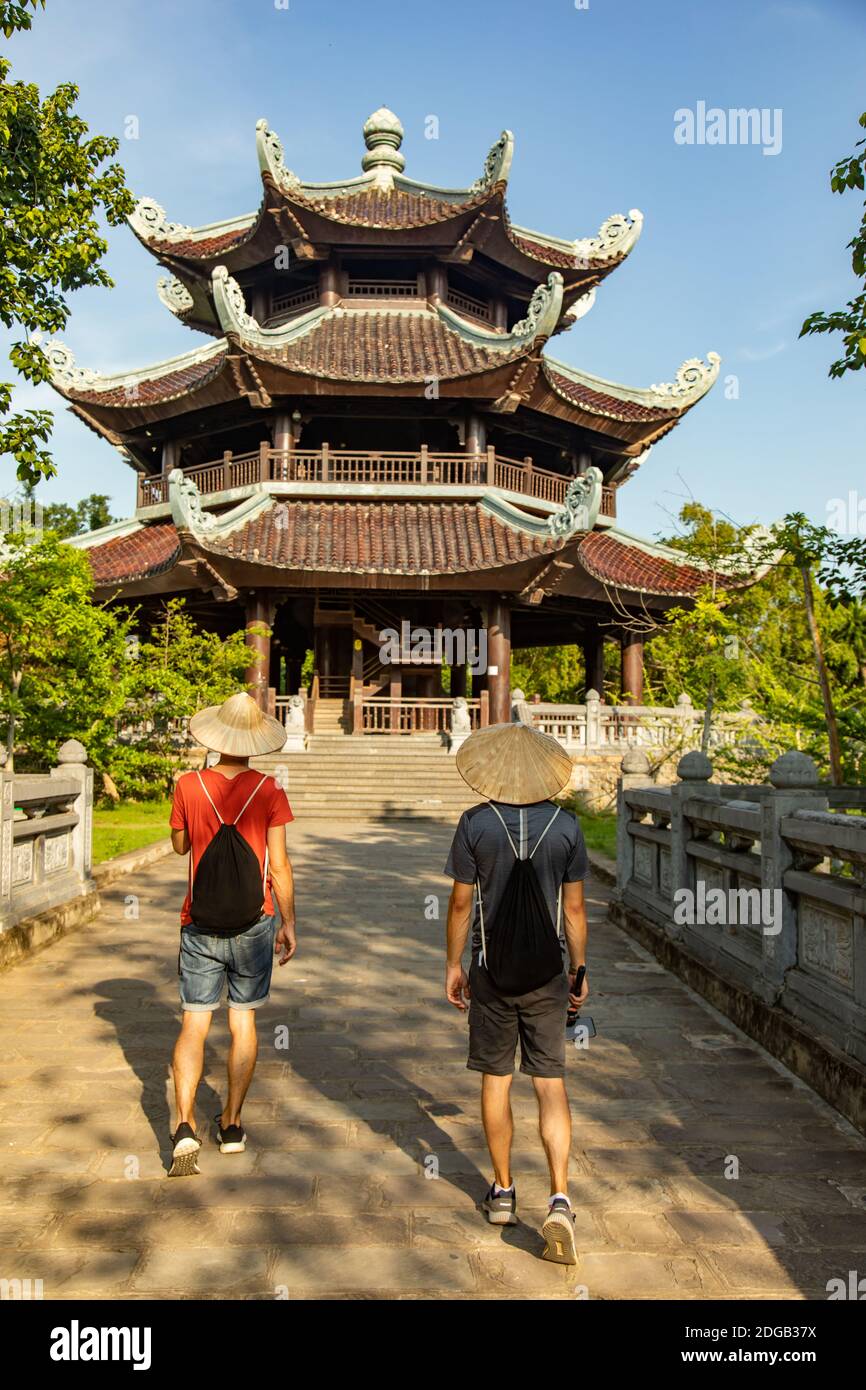 Two tourists walking towards a pagoda in Bai Dinh Buddhist temples complex, the biggest one in Vietnam, located in Ninh Binh province. Stock Photo