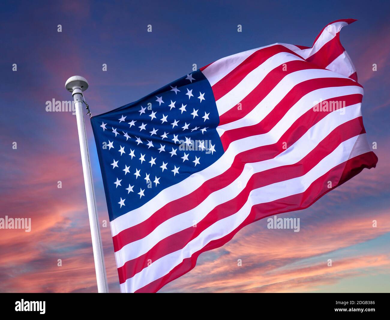 AMERICAN FLAG STARS & STRIPES SKY FLYING USA United States America American Stars and Stripes flag flying clean fresh, in breeze with red sunrise sky behind Stock Photo