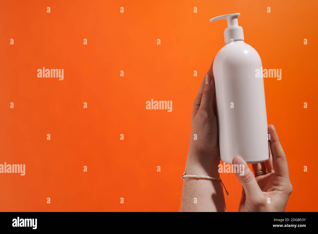 Woman's hands showing lotion blank bottle isolated Stock Photo - Alamy