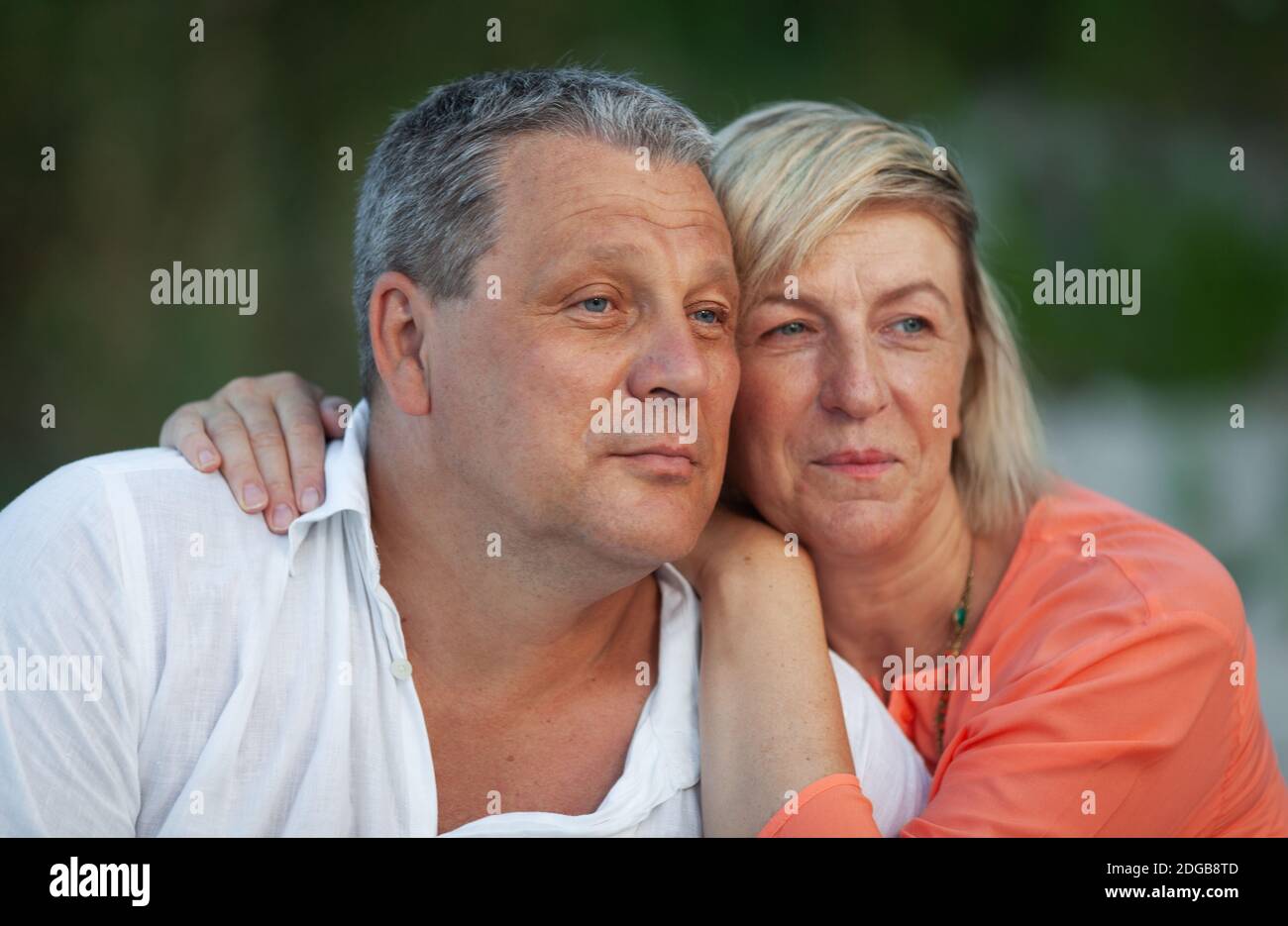 A portrait of a smiling middle aged couple looking into the distance Stock Photo