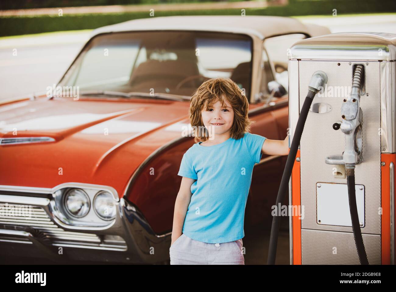 Retro gas station. Smiling Kid boy at the gas station. Waiting for fuel