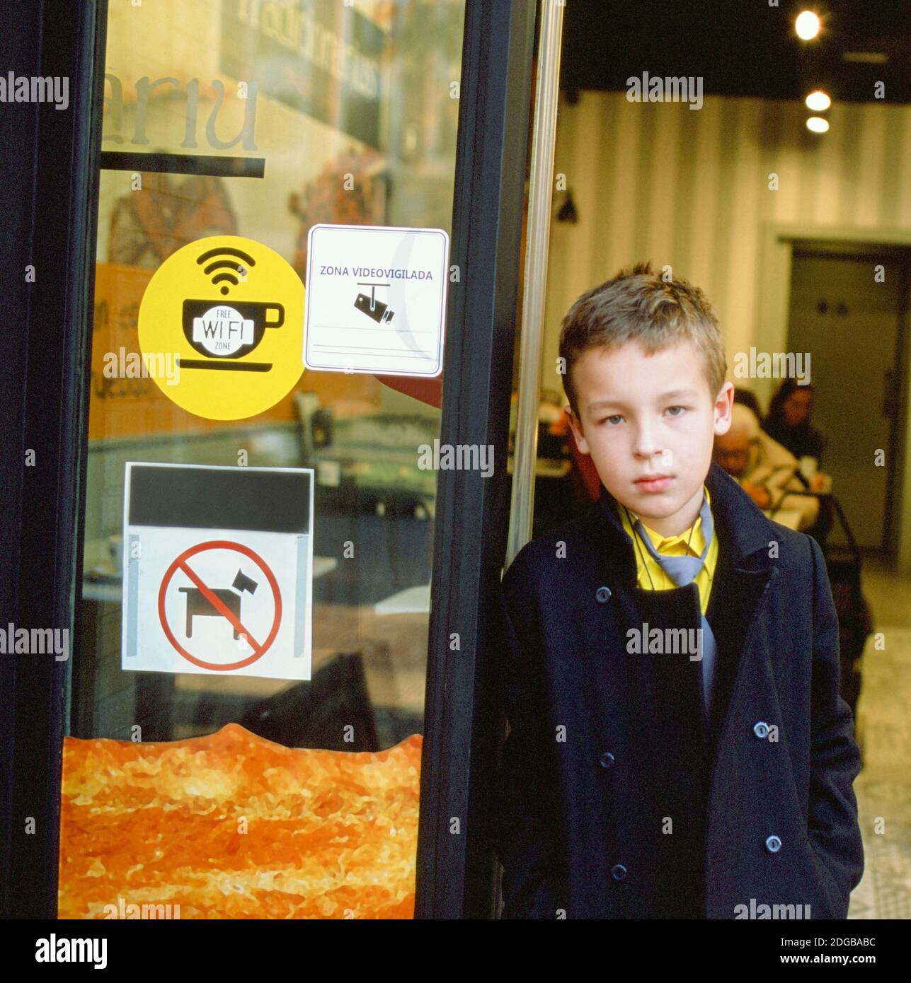 Schoolchild at the cafe doorway Stock Photo