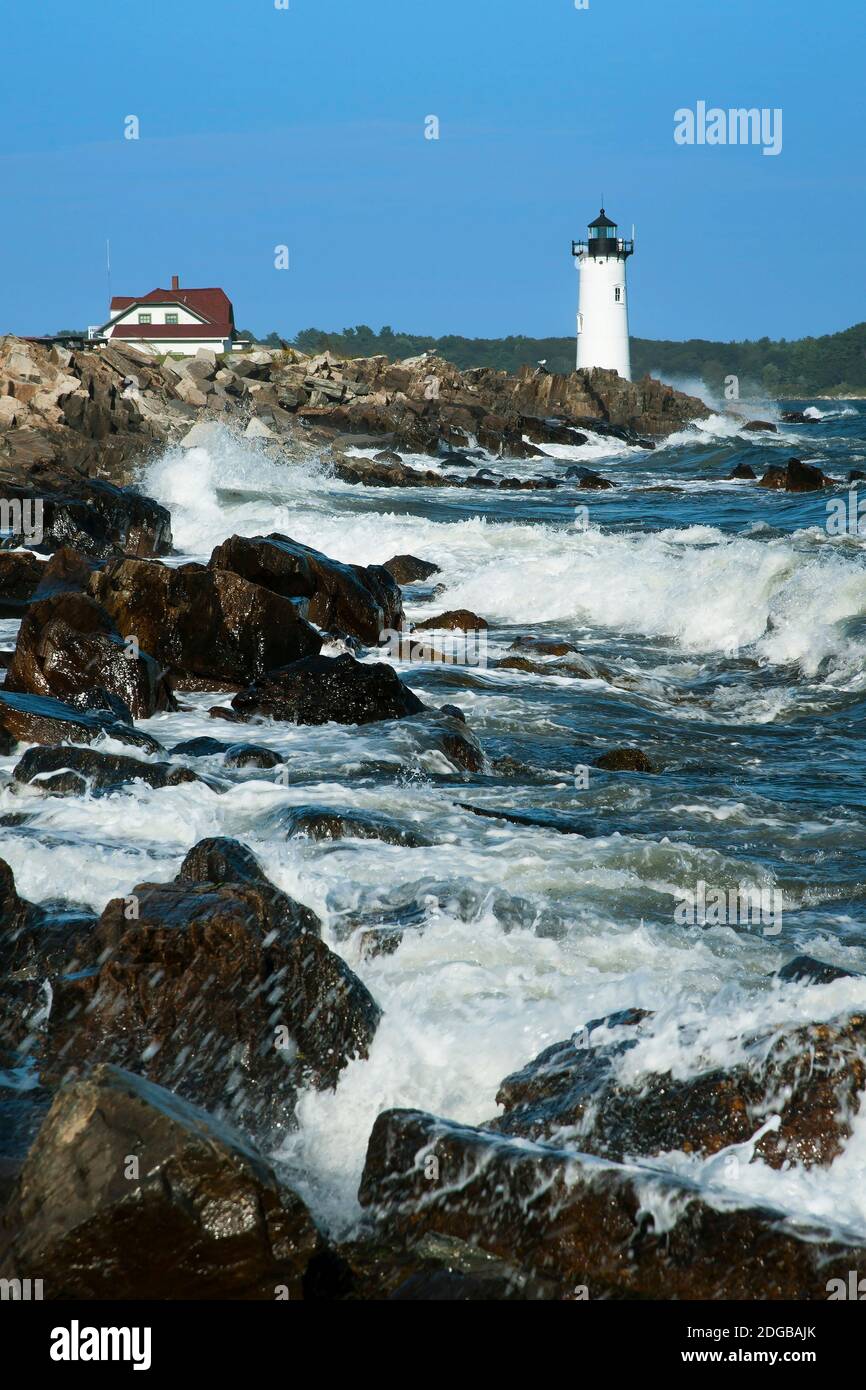 During high tide waves crash against the rocky shoreline by Portsmouth Harbor lighthouse, also referred to as Fort Constitution light, as the area is Stock Photo