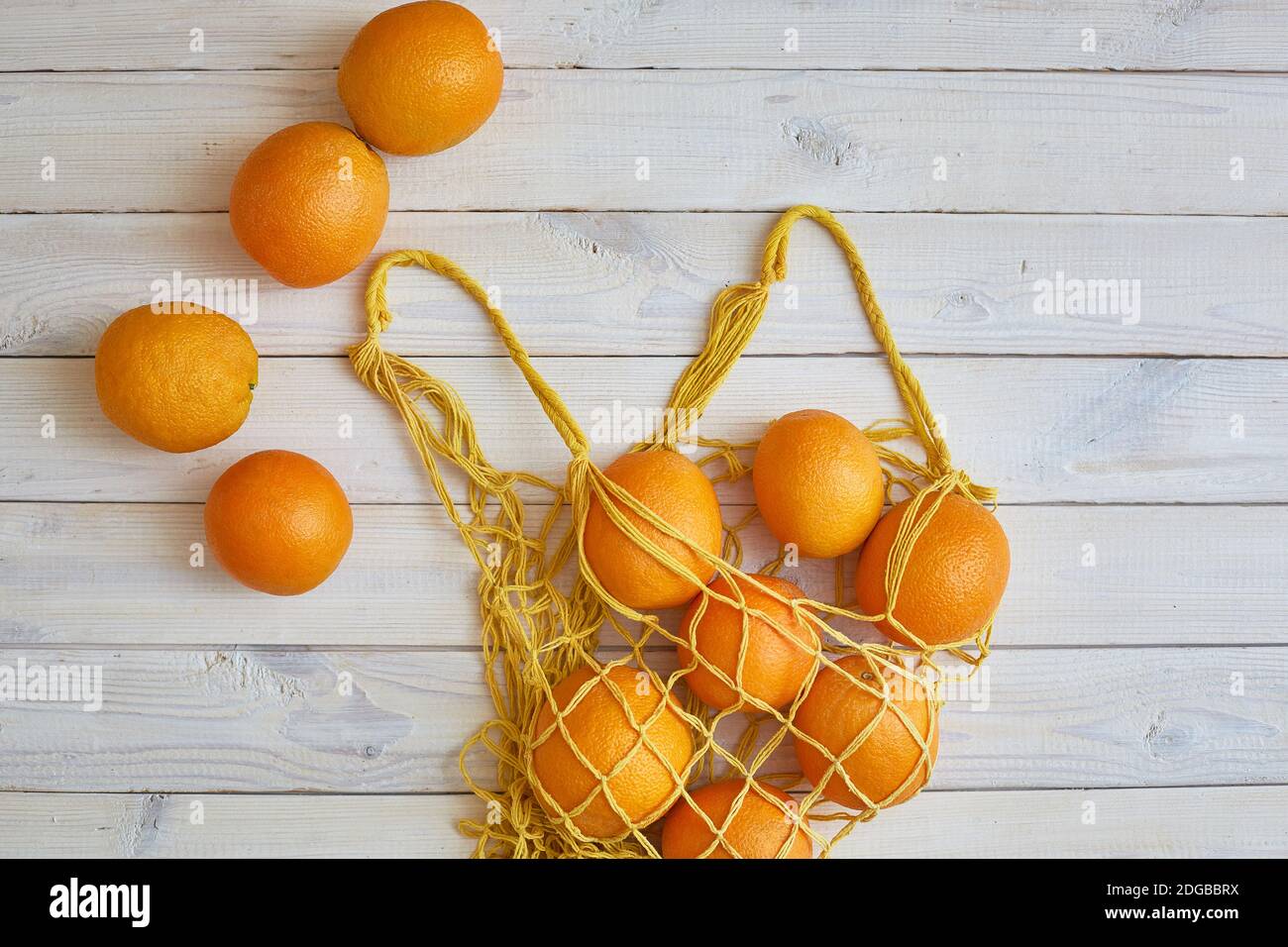 Top view of fresh oranges in string bag over white rustic background ...