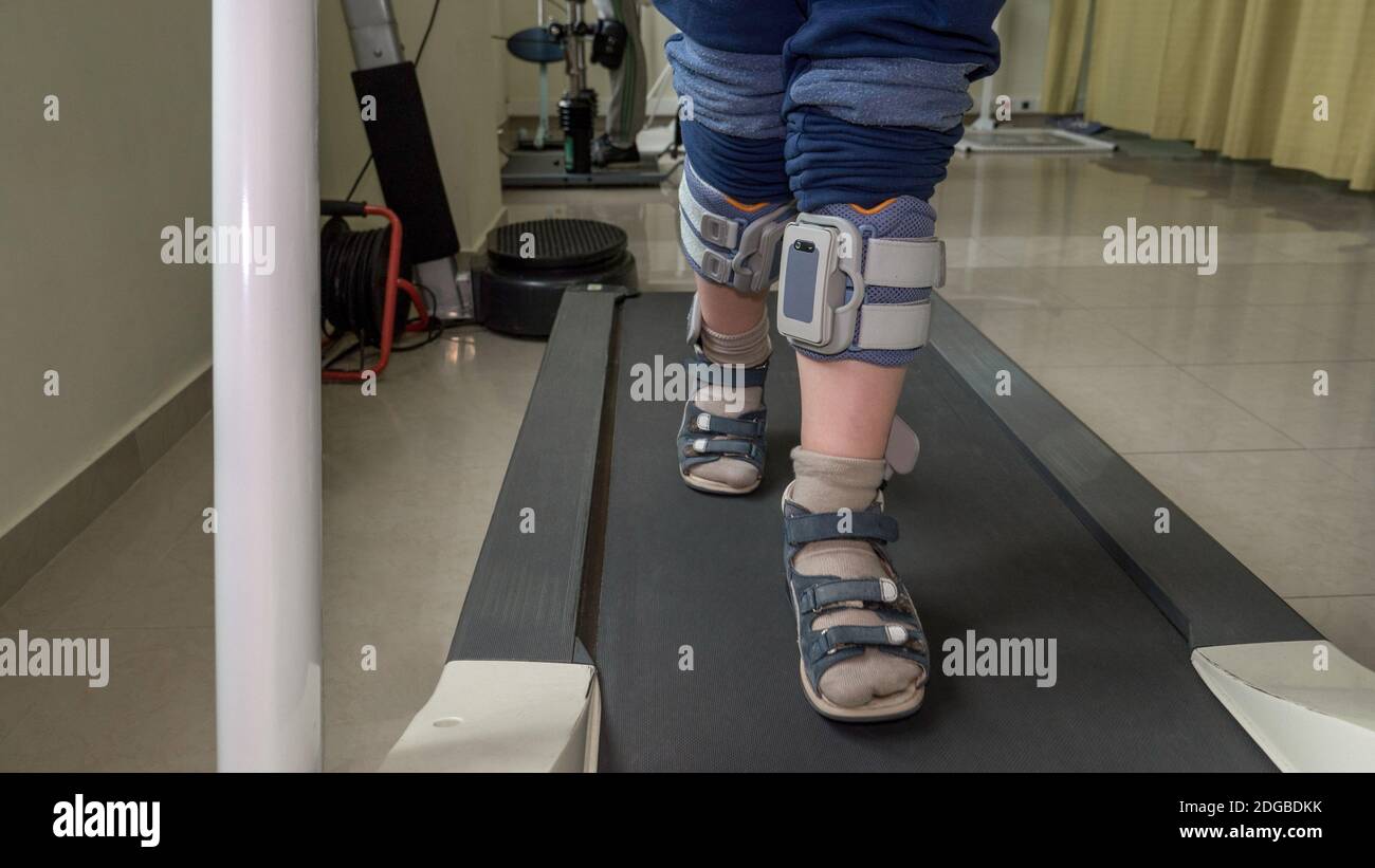 Child with foot drop system walking on the treadmill Stock Photo