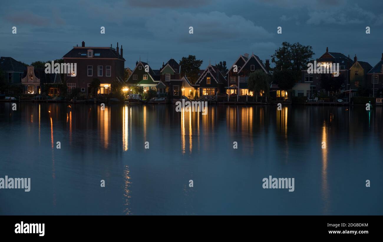 Waterside Dutch village with lights reflection on water at night Stock Photo