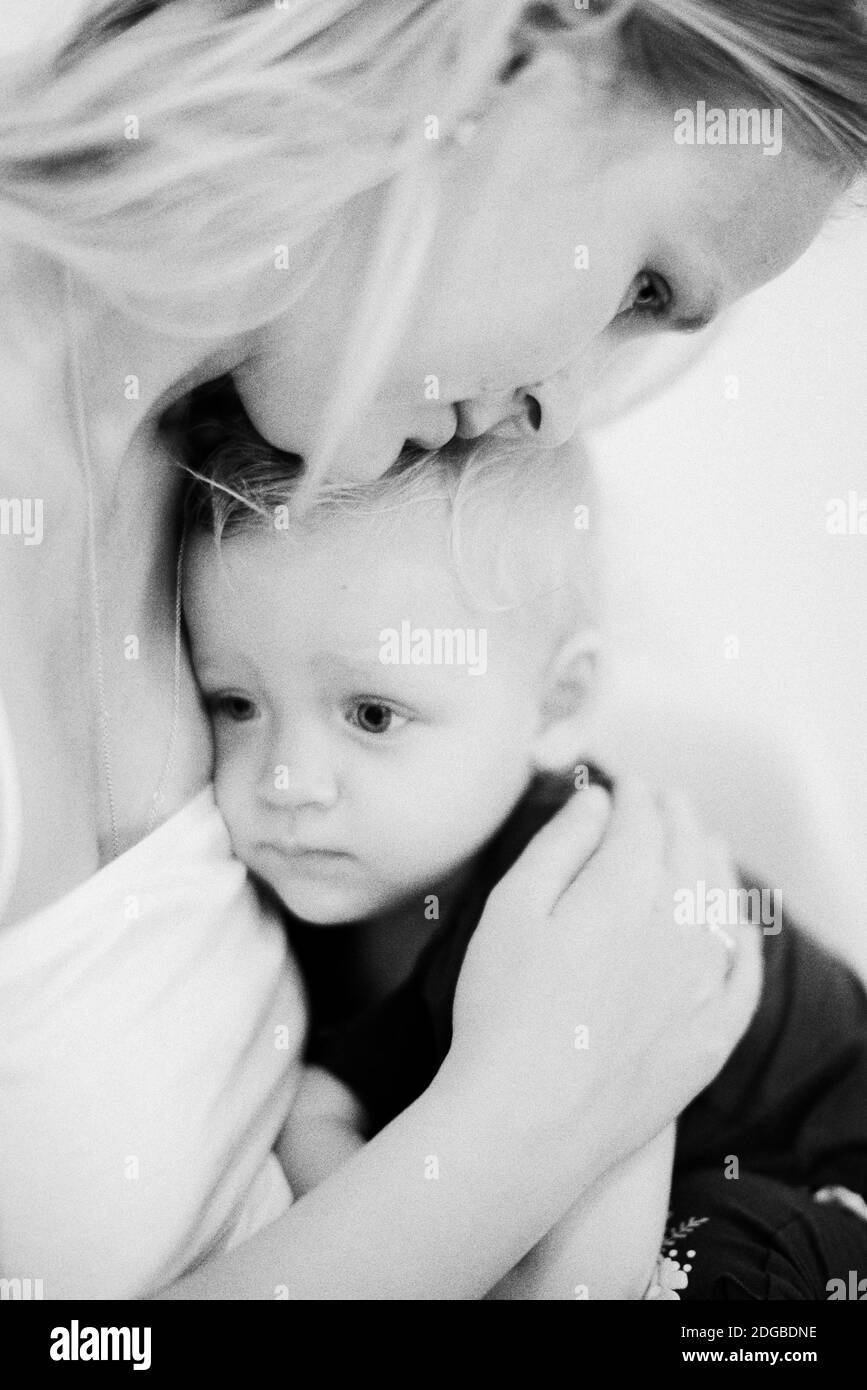 Mum embracing little daughter. Black and white shot Stock Photo
