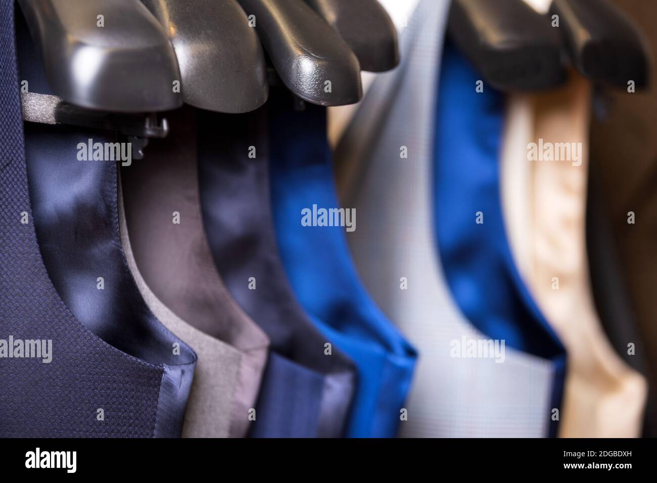 Stylish men's vest close up. Male svest hanging in a row. Men's Clothing, shopping in boutiques. vest and suits in a male luxury Stock Photo