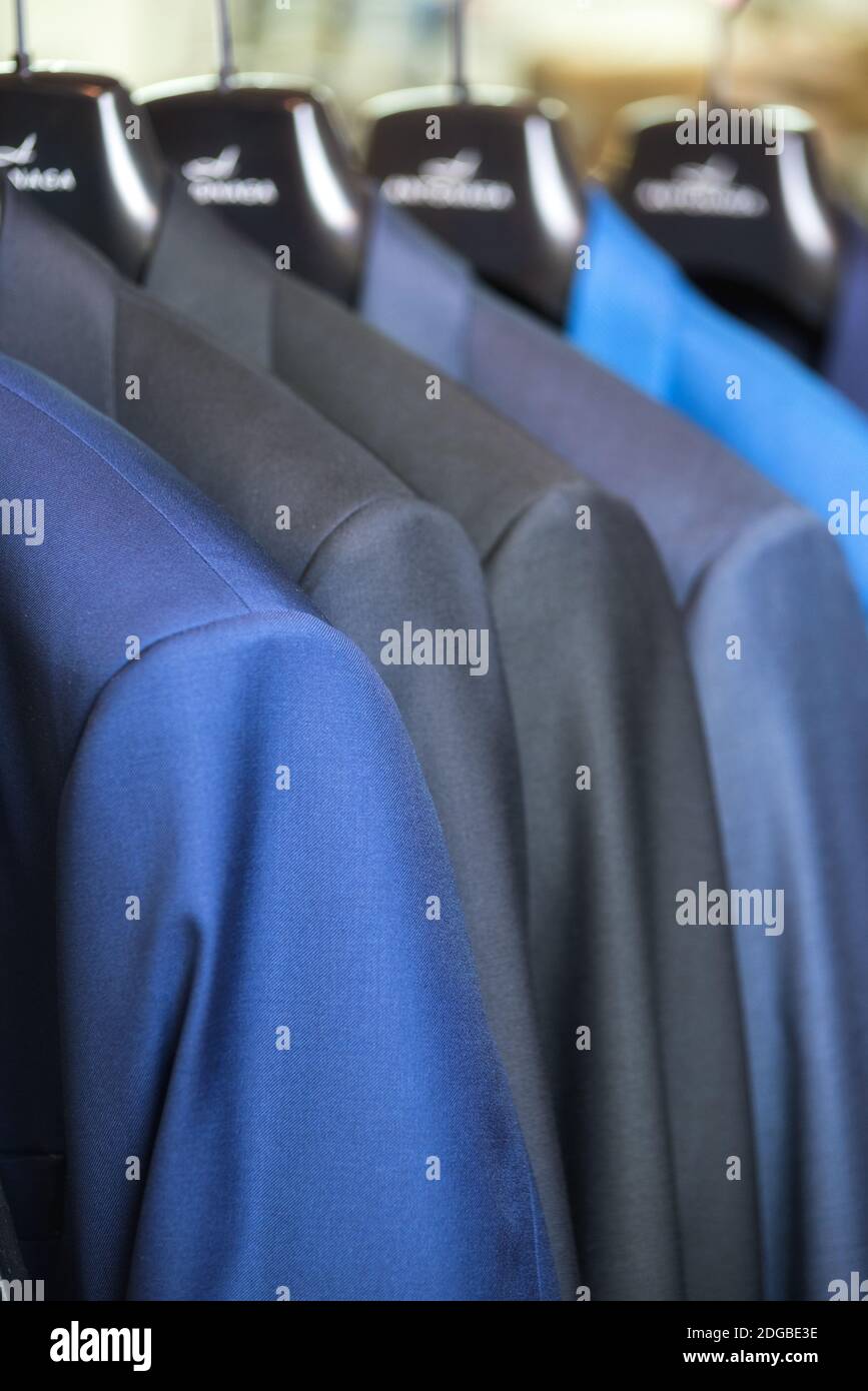 Close up luxurious style gentlemen suit row, hanging in a closet. Stock Photo
