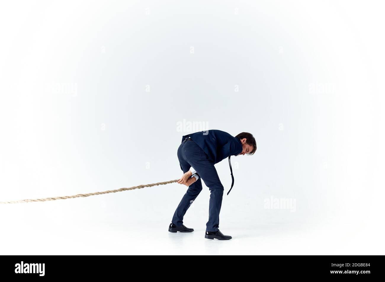 business man with a rope in his hands on a light background tension model  of achieving the goal Stock Photo - Alamy