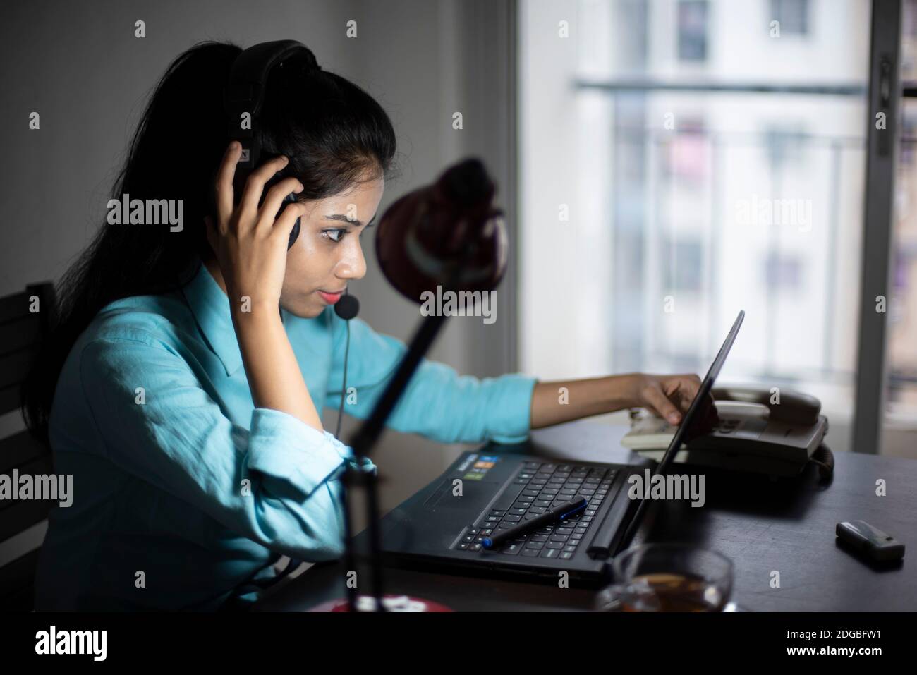 An Indian Bengali young woman/telecaller in office wear is