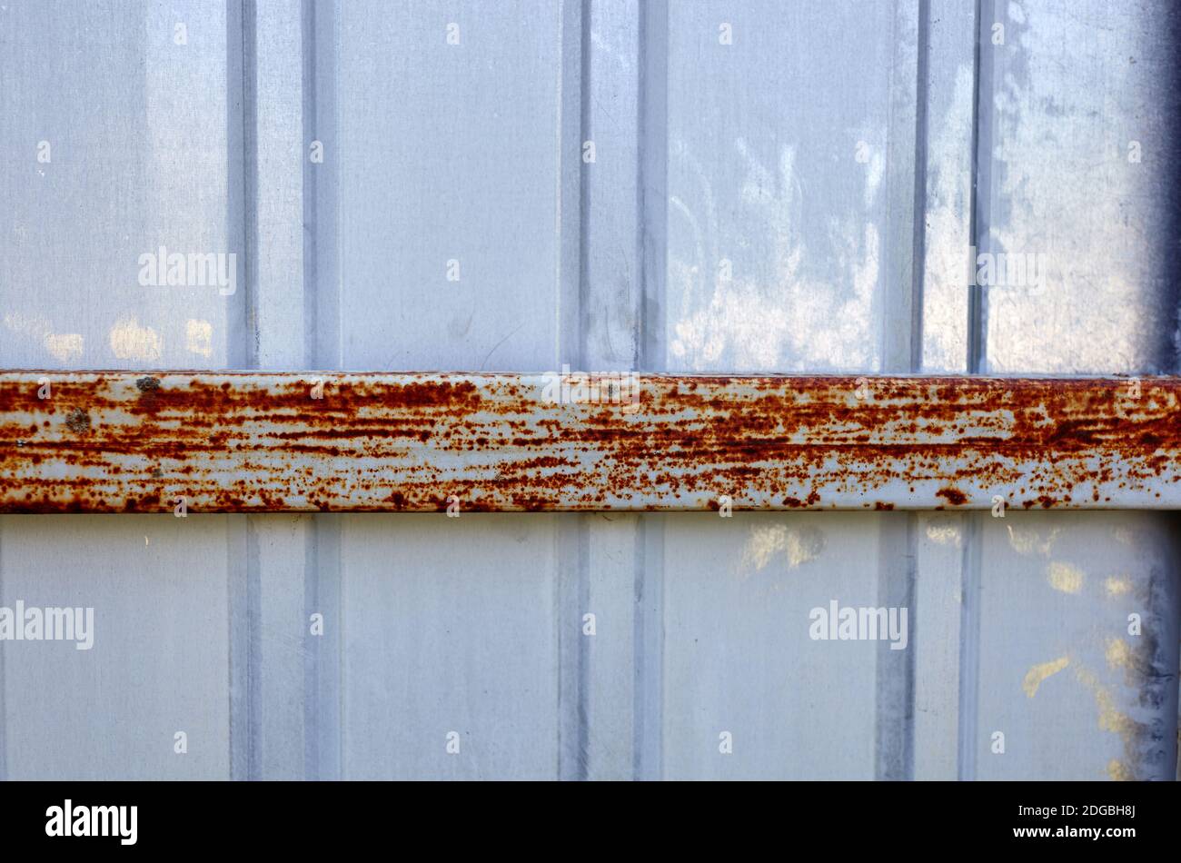 Iron rusty fence. White corrugated metal or zinc texture surface or galvanize steel in the vertical line background Stock Photo