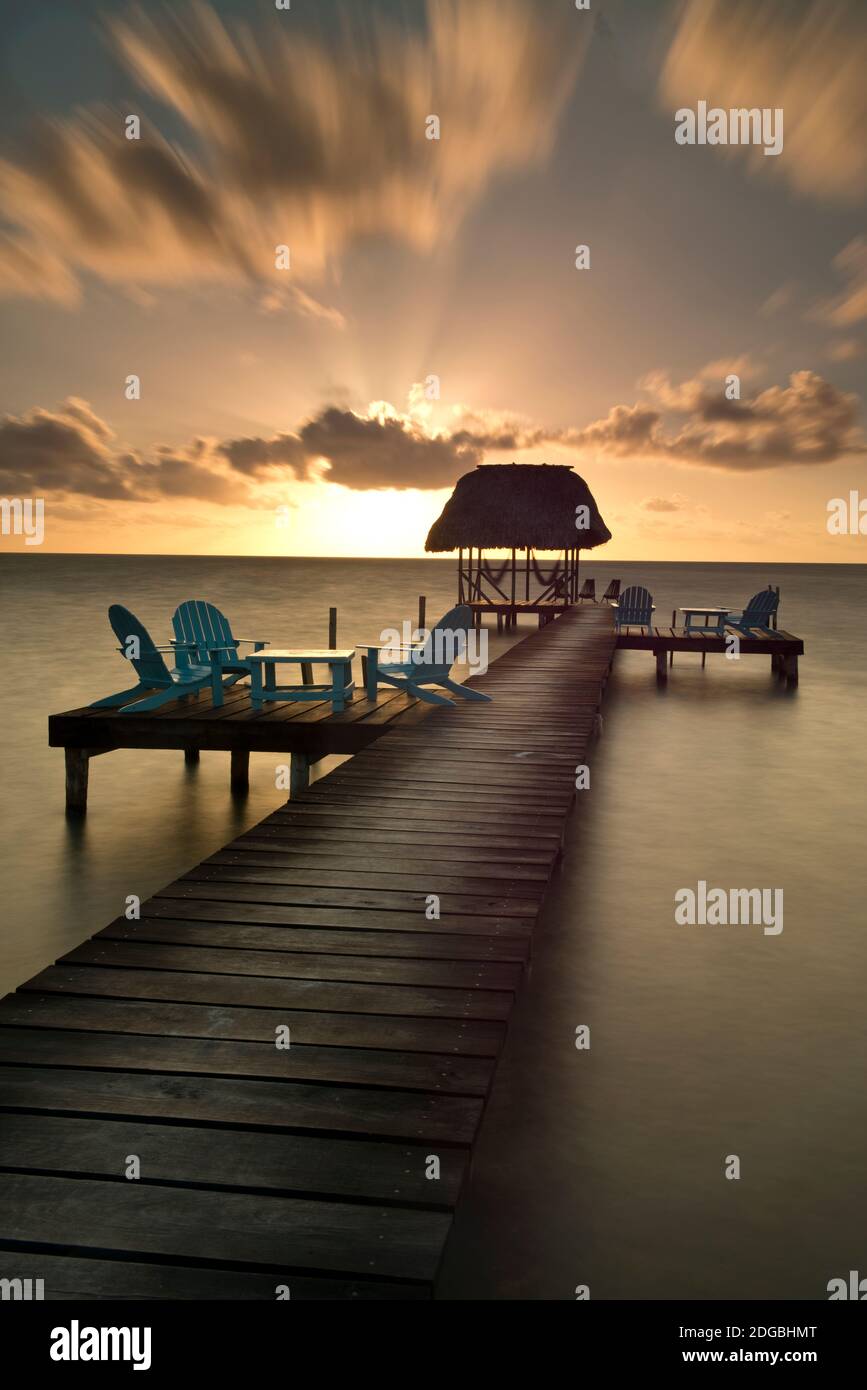 Pier with palapa on Caribbean Sea at sunrise, Caye Caulker pier, Belize Stock Photo