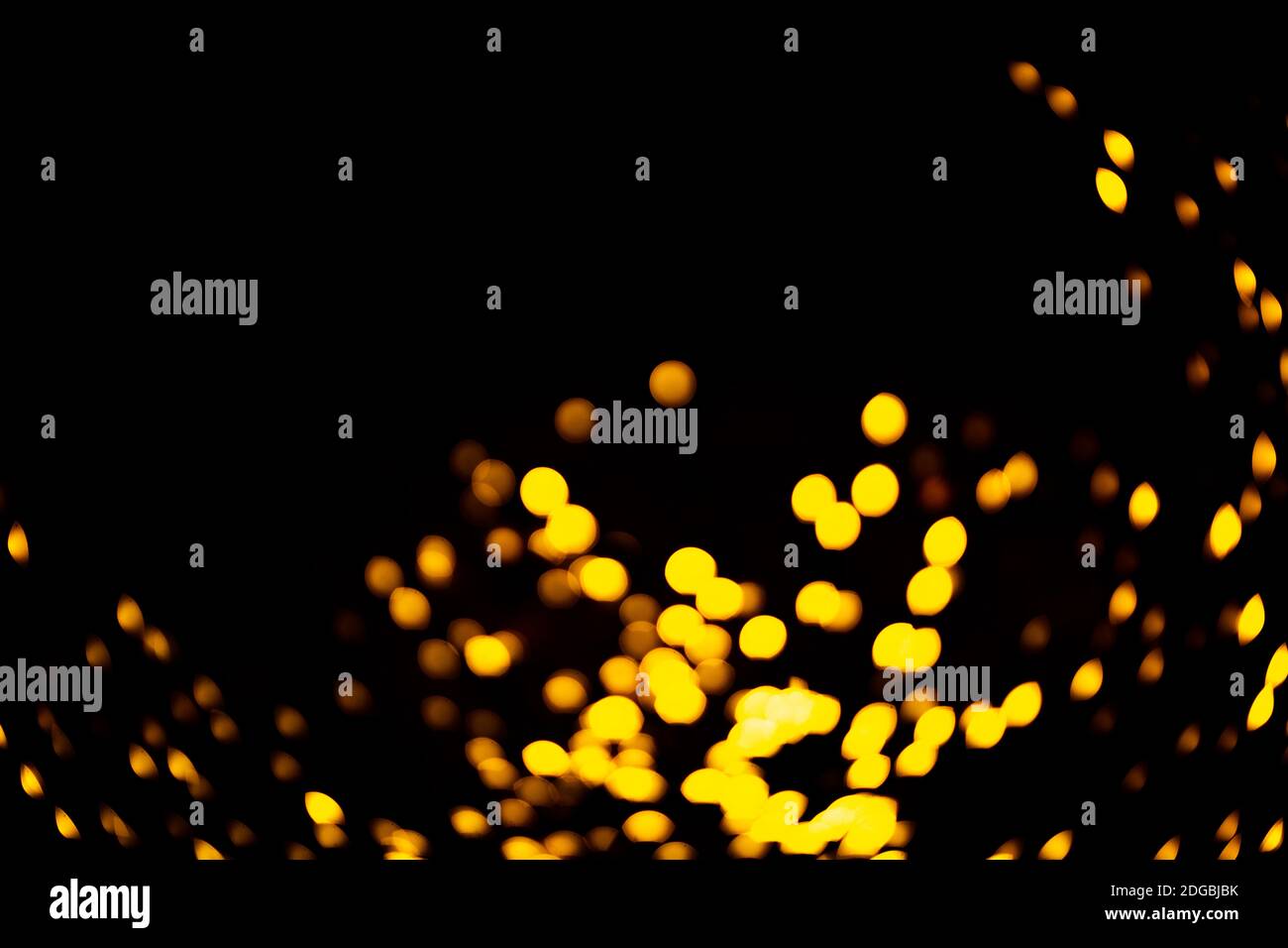 Bright orange specks of light garland shining in dark room during